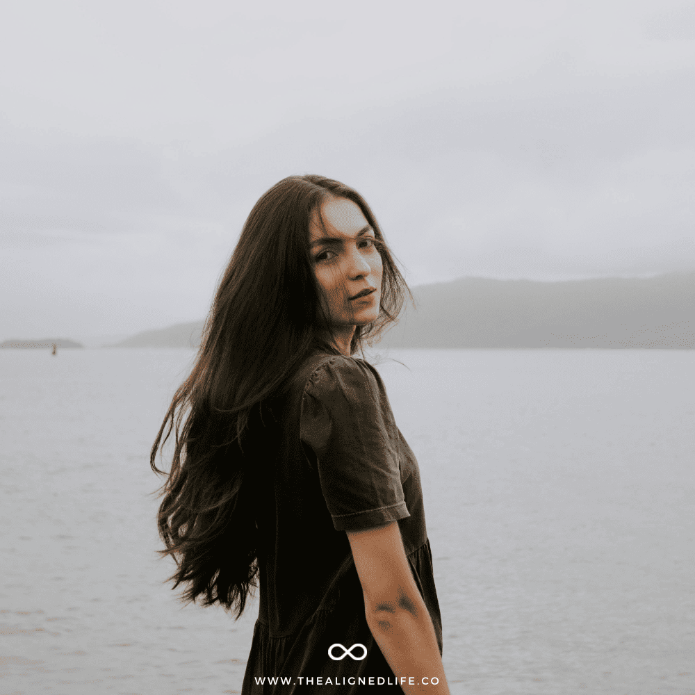 woman with long brown hair standing in front of the ocean | 3 Methods for Instant Manifestation | The Aligned Life Manifestation Blog