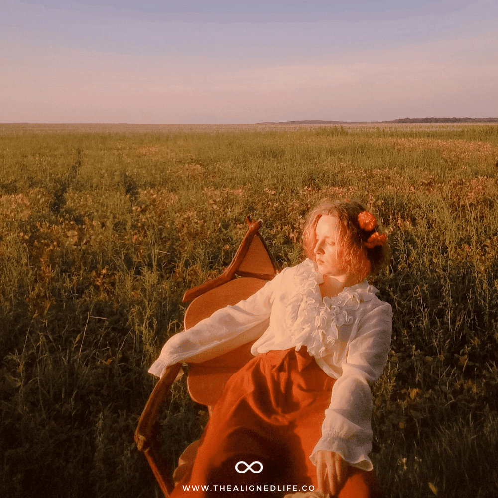 woman with a flower crown sitting in a chair in a field | How To Develop Your Intuition | The Aligned Life Manifestation Blog