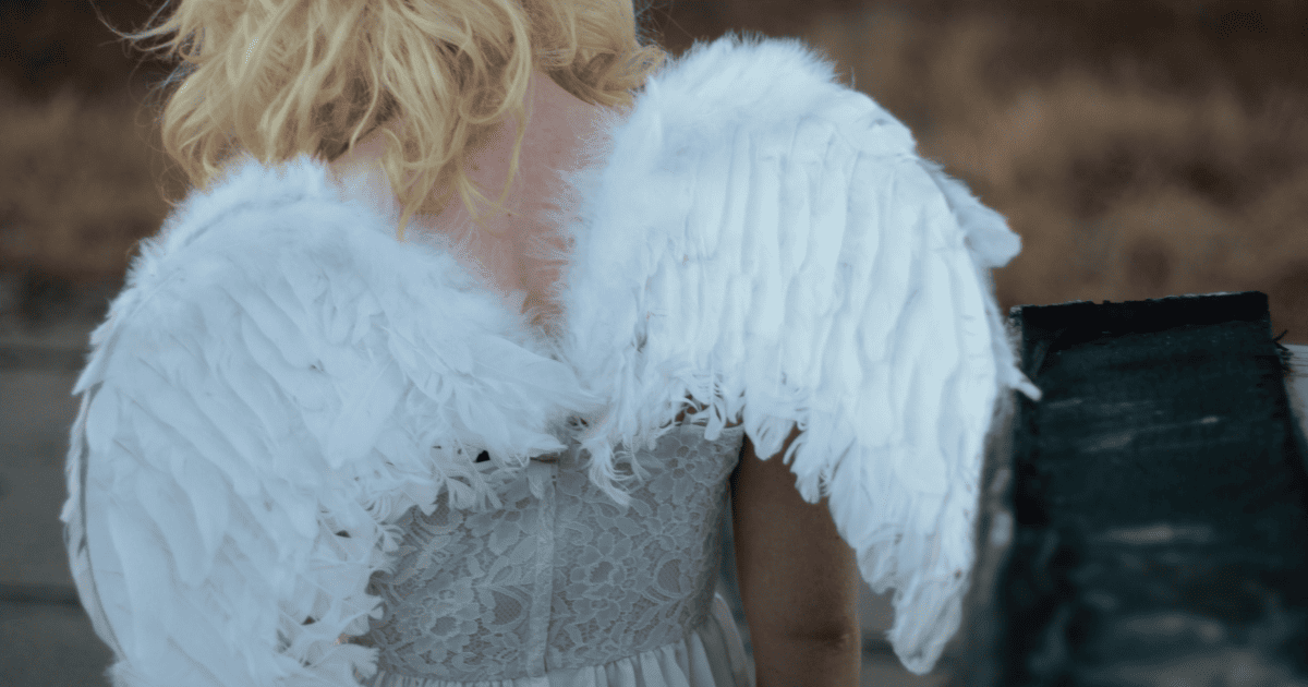 blonde girl wearing angel wings | How To Manifest With Angel Numbers | The Aligned Life Manifestation Blog