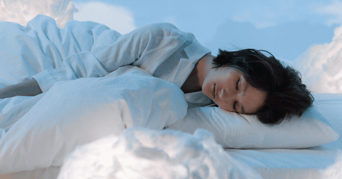 woman in the clouds with her head on a pillow | How To Use The Pillow Manifestation Method | The Aligned Life Manifestation Blog