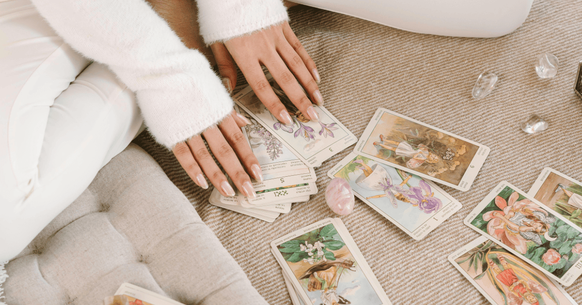 woman sitting on the floor with tarot cards and crystals | How To Use Tarot Cards For Manifestation | The Aligned Life Manifestation + Spirituality Blog