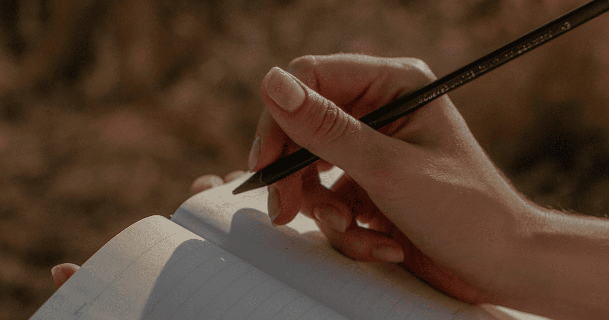 hand with pen and journal | 100+ Shadow Work Journal Prompts