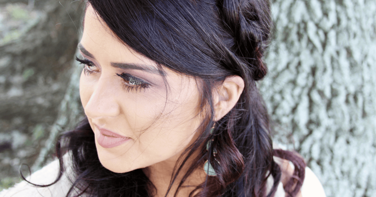 brunette woman looking over her shoulder | 10 Ways To Connect With Your Spirit Guides | The Aligned Life Manifestation Blog