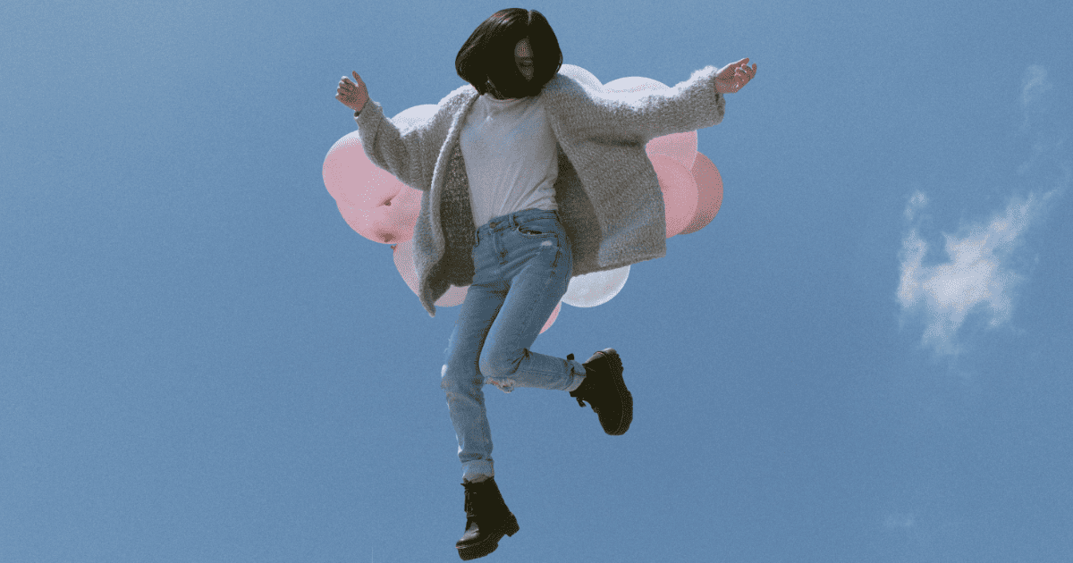 blue sky with brunette woman jumping | How To Improve Your Self-Concept For Manifestation