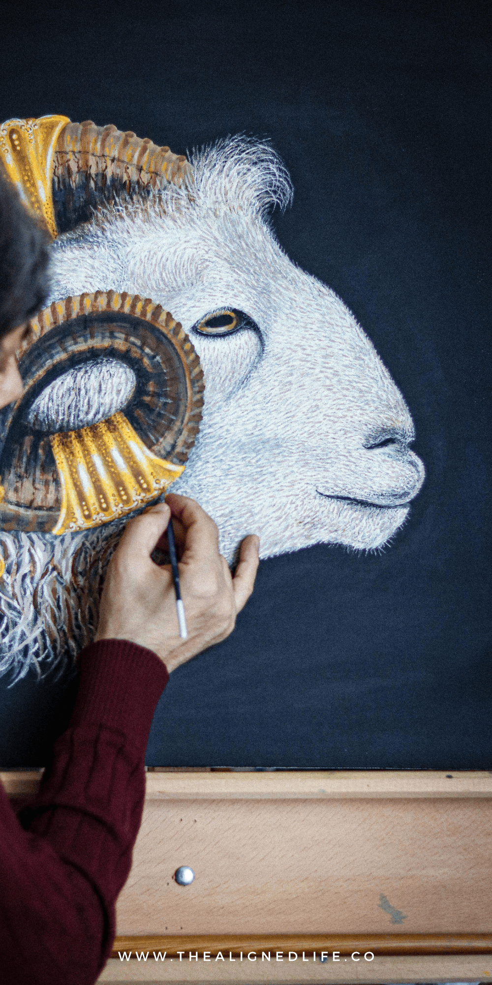 man painting a goat on a blue wall | Capricorn Season Guide: Rituals, Journal Prompts + More