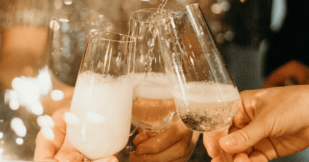 woman in a sequinned dress pouring champagne | How To Set Spiritual New Years Resolutions