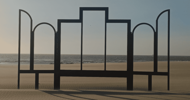 a black metal screen with windows on a beach
