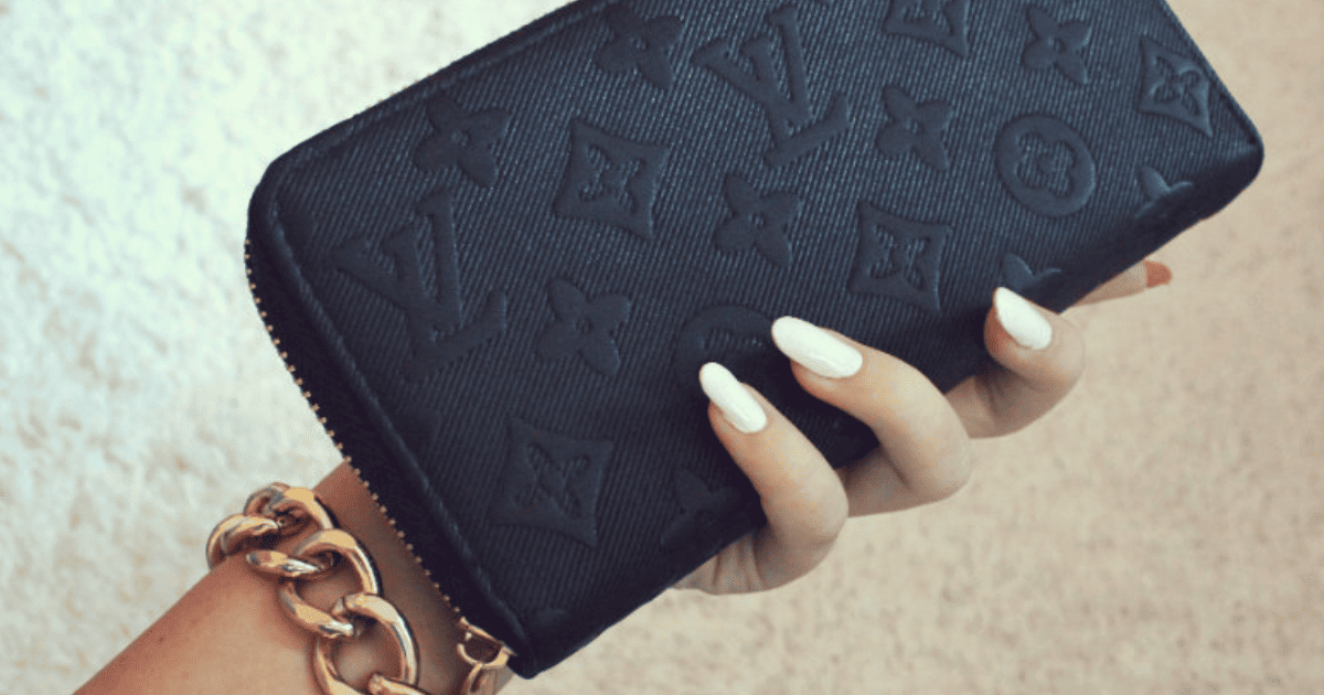 woman's hand with white manicure holding a black Louis Vuitton wallet | 10 Feng Shui Tricks for Money & Abundance