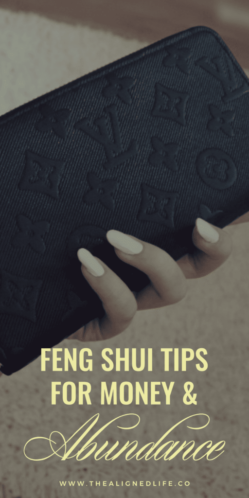 woman's hand with white manicure holding a black Louis Vuitton wallet | 10 Feng Shui Tricks for Money & Abundance