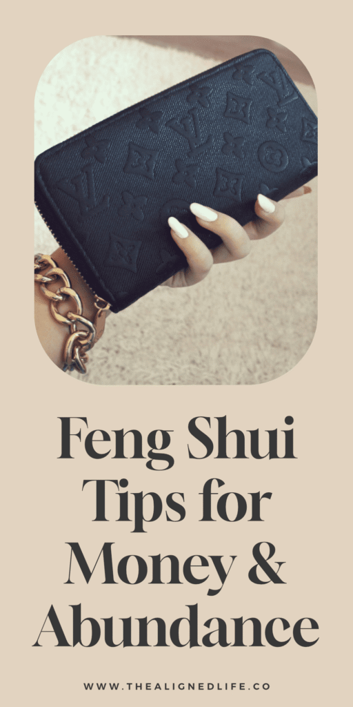 woman's hand with white manicure holding a black Louis Vuitton wallet | 10 Feng Shui Tricks for Money & Abundance